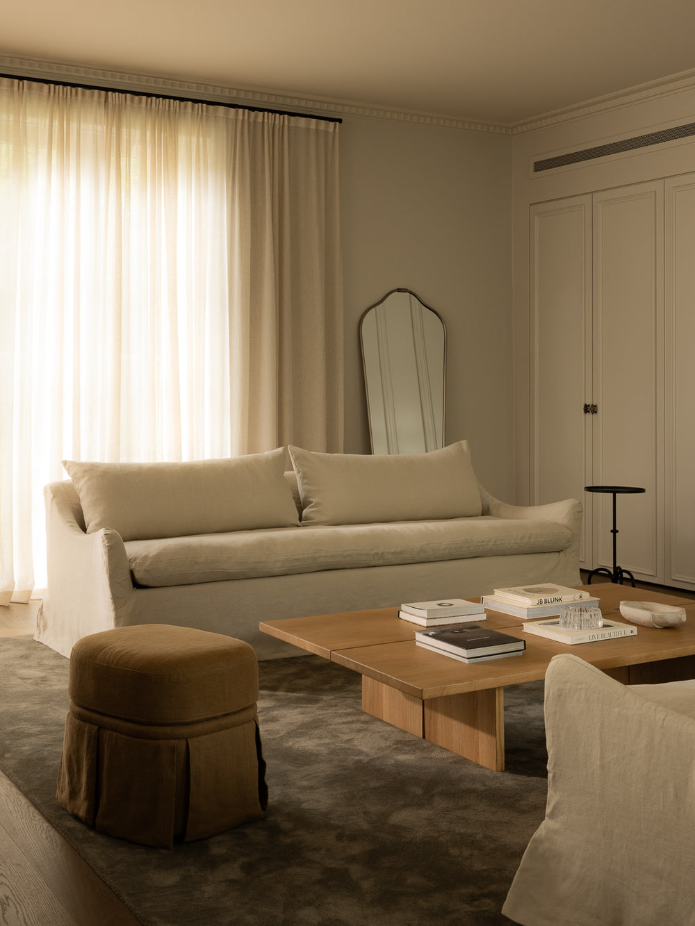 Modern living room with beige sofa, wooden coffee table, and decorative items.